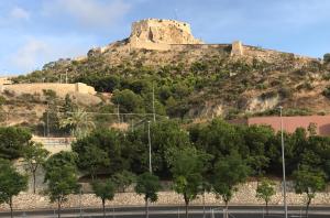 a castle on top of a hill with trees at Castle Apartment in Alicante
