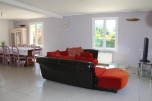 ein Wohnzimmer mit einem roten Sofa und einem Tisch in der Unterkunft Chambre d'hôte in Fay-les-Étangs