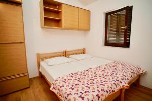 niewielka sypialnia z łóżkiem i oknem w obiekcie Apartment Mar y amore w mieście Seget Vranjica