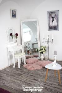 a room with a mirror and a table and a stool at Korona Apartman Székesfehérvár in Székesfehérvár