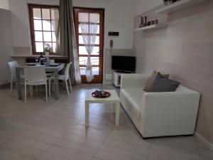 a living room with a white couch and a table at Gina's Apartment in Riva di Solto