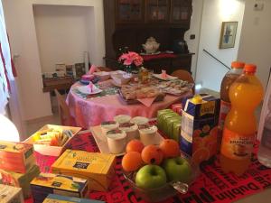 een tafel gevuld met eten en drinken en een tafel met snacks bij La Torre di Clo B&B in Dolceacqua