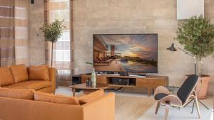sala de estar con TV de pantalla plana en la pared en Villa Ana, en Splitska