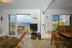 a living room with a television and a table and chairs at All About the Sea - Riviera House near the center of Hvar in Hvar