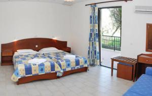 a bedroom with a bed and a sliding glass door at Red Rose Garden in Tsilivi