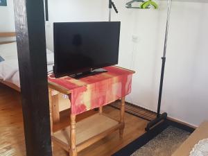 a television on a wooden table with a stand with a tv at Apartment Labud in Legrad