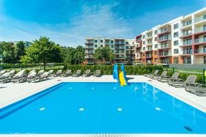 a swimming pool with lounge chairs and a apartment at Apartament „Nova Polana” Kołobrzeg Polanki Park in Kołobrzeg