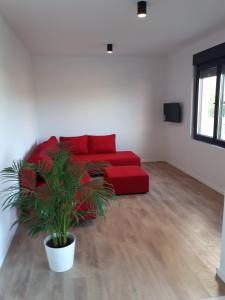 a red couch in a living room with a plant at Sea Melody in Lopar