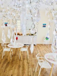 una sala da pranzo con tavoli bianchi e sedie bianche di Flowers Sweet Rooms B&B a Vasto