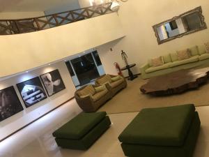a large living room with two couches and a table at Porto Praia do Forte in Praia do Forte