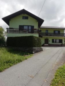 una casa amarilla con un camino delante en Apartmaji Karbic en Postojna