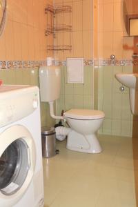 ein Badezimmer mit einem WC, einem Waschbecken und einer Waschmaschine in der Unterkunft Las Palmas in Pomorie