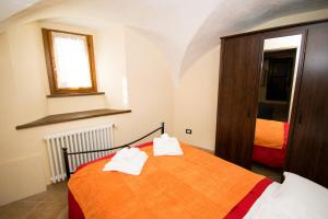 Una habitación con una cama con dos toallas. en Baita della Fontana en Pragelato
