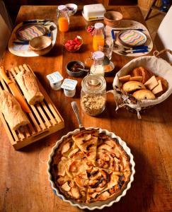- une table en bois avec une tarte et du pain dans l'établissement La Cascadeta, à Marignac-Lasclares