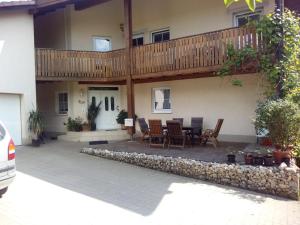 een patio met een tafel en stoelen en een balkon bij Gästezimmer Fechheim in Neustadt bei Coburg