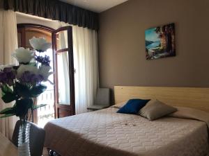 a bedroom with a bed and a vase of flowers at Hotel La Sirenetta in Giardini Naxos