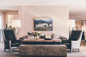 a living room with a coffee table and two chairs at Golserhof in Tirolo