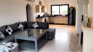 a living room with a couch and a table at VILLA 186 AGADIR in Islane