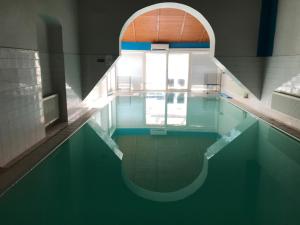 a pool of water with a large window in a building at Club M.K.M. Modra in Modra
