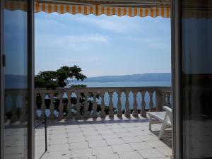 a balcony with a bench and a view of the ocean at Apartments Tomas in Senj