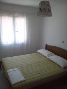 Schlafzimmer mit einem großen Bett und einem Fenster in der Unterkunft City Center Apartment in Himarë