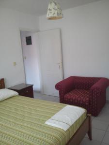 ein Schlafzimmer mit einem Bett, einem Sofa und einem Stuhl in der Unterkunft City Center Apartment in Himarë