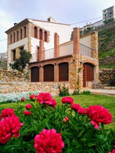 a house with red flowers in front of it at Casa Rural Caseta de l' Hort in Villafranca del Cid