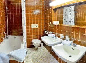 シェーナウ・アム・ケーニッヒスゼーにあるPension Gretiのバスルーム(洗面台2台、バスタブ、トイレ付)