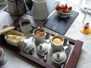 a tray with cups and bowls of food on a table at Eco Logis de Chantegrolle in Champagne-Mouton +44 photos