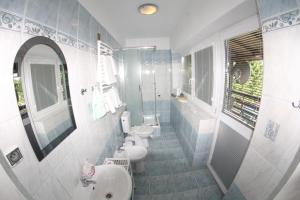 een badkamer met 2 toiletten, een wastafel en een spiegel bij AS Gościniec in Mikołajki