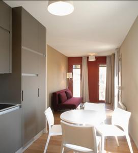 een woonkamer met een witte tafel en stoelen bij Temporesidence Cathedrale in Bayonne