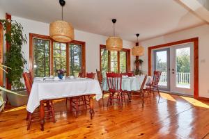a dining room with tables and chairs and windows at Auberge de la Tour et Spa in Magog-Orford