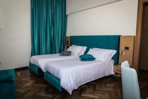 una camera con un grande letto con testiera verde di Palazzo Filisio - Regia Restaurant a Trani