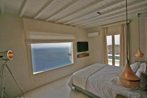 1 dormitorio con cama y ventana grande en Atlantis Beach Residence en Super Paradise Beach