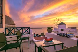 a rainbow in the sky over the ocean at sunset at Evilio Houses in Oia