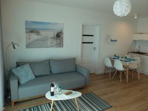 ein Wohnzimmer mit Sofa und Tisch in der Unterkunft Apartament 33BalticBlue in Pogorzelica