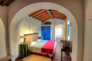 Schlafzimmer mit einem Bett mit einer roten und weißen Decke in der Unterkunft Hotel Rural Monte Da Rosada in Estremoz