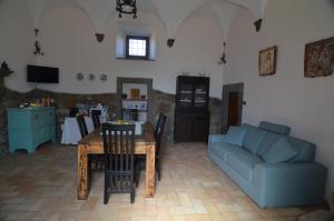 a living room with a table and a blue couch at Magica Torre Medievale in Viterbo