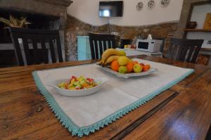 una mesa con un tazón de fruta y un tazón de ensalada en Magica Torre Medievale en Viterbo