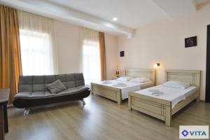 pokój hotelowy z 2 łóżkami i kanapą w obiekcie Hotel Vita w mieście Tbilisi City