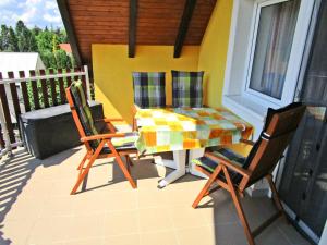 eine Terrasse mit einem Tisch und Stühlen auf dem Balkon in der Unterkunft Villa Schwalbennest in Vonyarcvashegy