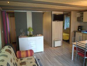 a living room and kitchen with a couch and a table at Le petit chalet in Porticcio