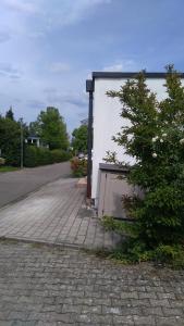 einen Ziegelsteinweg neben einem Gebäude mit einem Baum in der Unterkunft TOM13 in Köngen