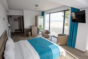 a hotel room with a bed and a view of the ocean at Belleview Suites in Mamaia