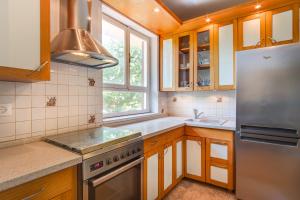 a kitchen with wooden cabinets and a stainless steel refrigerator at Bandalo in Mali Lošinj