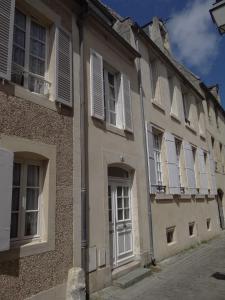 a building with white windows and shutters on it at Le 4 in Bayeux
