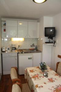 a small kitchen with a table and a sink at Éva Vendégház in Bük