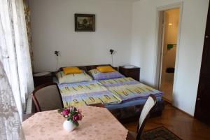 a bedroom with two beds and a table and chairs at Éva Vendégház in Bük