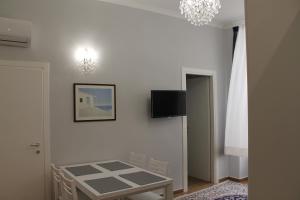 ナポリにあるNunzia Sweet Homeの壁にテーブルとテレビが備わる部屋