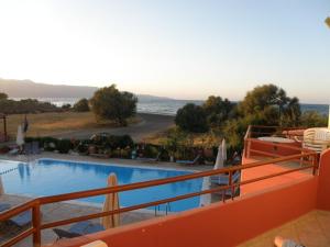 a large swimming pool with a view of the ocean at Haridimos Apartments in Tavronitis